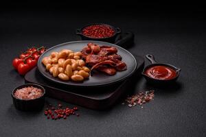 Fried sausages sliced with salt and spices as an ingredient for an English breakfast photo