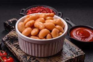Delicious nutritious canned beans in tomato, with salt and spices photo