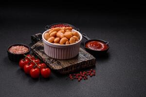 Delicious nutritious canned beans in tomato, with salt and spices photo