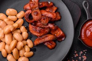 Fried sausages sliced with salt and spices as an ingredient for an English breakfast photo