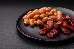Fried sausages sliced with salt and spices as an ingredient for an English breakfast photo