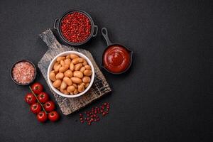 Delicious nutritious canned beans in tomato, with salt and spices photo