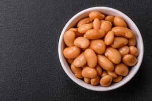 Delicious nutritious canned beans in tomato, with salt and spices photo