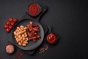 Fried sausages sliced with salt and spices as an ingredient for an English breakfast photo