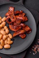 Fried sausages sliced with salt and spices as an ingredient for an English breakfast photo