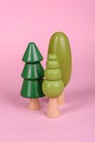 Wooden model of a tree with a green crown and trunk on a pink background photo