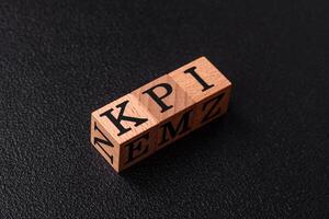 Inscription KPI Key Performance Indicator with wooden cubes photo