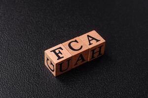 Inscription FCA wooden cubes, conceptual background with copy space photo