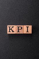 Inscription KPI Key Performance Indicator with wooden cubes photo