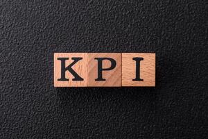 Inscription KPI Key Performance Indicator with wooden cubes photo