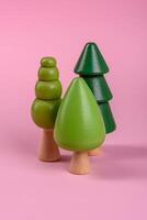 Wooden model of a tree with a green crown and trunk on a pink background photo