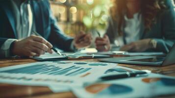 Business professionals discussing financial documents in a meeting with charts and graphs laid out on a wooden table, reflecting analysis, teamwork, and corporate strategy. photo