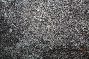 Rough, grey, dark harsh and high contrast granite stone texture background. A close-up of the surface of abstract natural rock. Natural Marble stone wallpaper. photo