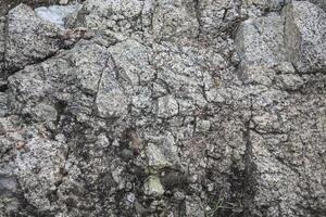 Rough, grey, dark harsh and high contrast granite stone texture background. A close-up of the surface of abstract natural rock. Natural Marble stone wallpaper. photo
