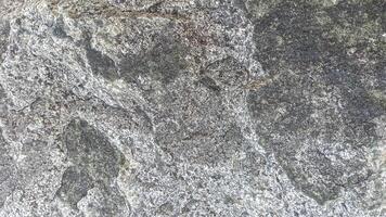 Rough, grey, dark harsh and high contrast granite stone texture background. A close-up of the surface of abstract natural rock. Natural Marble stone wallpaper. photo
