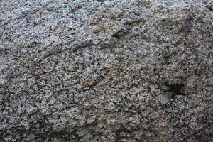 Rough, grey, dark harsh and high contrast granite stone texture background. A close-up of the surface of abstract natural rock. Natural Marble stone wallpaper. photo