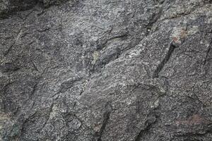 Rough, grey, dark harsh and high contrast granite stone texture background. A close-up of the surface of abstract natural rock. Natural Marble stone wallpaper. photo