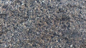 Rough, grey, dark harsh and high contrast granite stone texture background. A close-up of the surface of abstract natural rock. Natural Marble stone wallpaper. photo