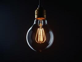 Luminous light bulb emphasizing electricity conservation on contrasting dark backdrop. photo