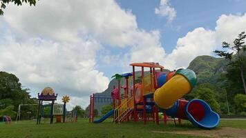 Timelapse empty colorful playground on the lawn in public park. Fast motion cloudy blue sky in the summer. video