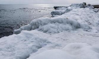 Ice-covered shore, rocks and coastal cliffs. The Black Sea is frozen photo