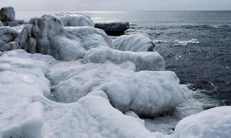 Ice-covered shore, rocks and coastal cliffs. The Black Sea is frozen photo