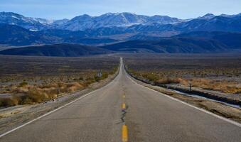 Straight Road in the California desert, going into the mountains near Death Valley National Park photo
