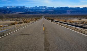 Straight Road in the California desert, going into the mountains near Death Valley National Park photo
