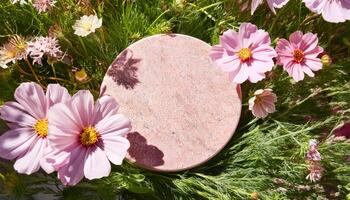Pink Flowers and a Round Stone in a Green Garden photo