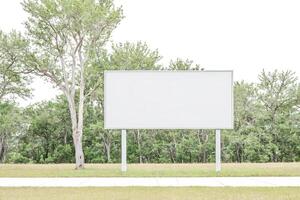 Blank Billboard with a Green Tree and Grass Background photo