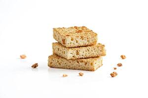 Stack of three crunchy square crackers with crumbs on a white background photo