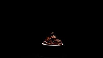 Raisins or dried grape food in a bowl rotating on black background video