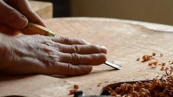 Hands of luthier working with a gouge in a new guitar video