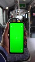 passenger sitting in a bus using his phone with green screen video