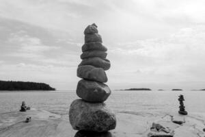 Stacked Rocks balancing, stacking with precision. Stone tower on the shore. Copy space. photo