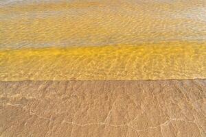 Patterns of light on the surface of the water over a sandy bottom. photo