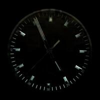 The watch dial is black. Shiny clock hands. photo
