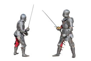 Knights in armor. Medieval knights in iron armor hold swords in their hands. Duel of the medieval warriors. The battle of two knights on swords. photo
