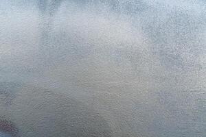 Silver paint on a rough wall. Abstract gray background. photo