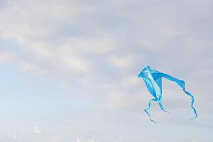 Blue kite in the sky with clouds in the background. photo