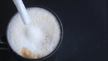 white sugar pouring from a in a paper packet on a coffee cup video