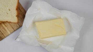 slice of a butter on a paper on table video