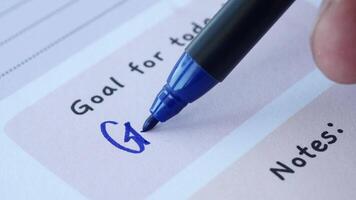 Goal Setting using a Blue Marker on a Planning Sheet for Enhanced Clarity and Organization video