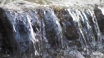 The tranquil water cascades over rocks in the beautiful setting of natures splendor video