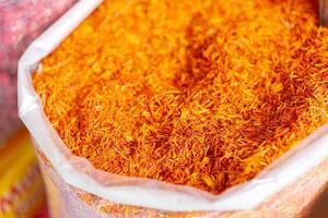 A bag of orange spice is shown in a white plastic bag photo