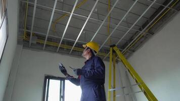 An electrician in uniform is inspecting the electrical system in a house. video