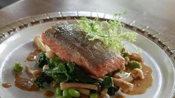 close up to a plate of fresh grilled salmon steak with fired mushroom ready to eat for main course dinner time video