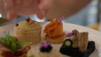 close up selective focus to canape sandwich in white plate while using hand to grab canape to eat in afternoon tea time video