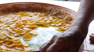 view while local people collect sweet mango paste from giant tray after dried sweet puree mango by the sun light video