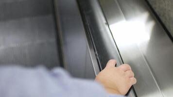 movement of the Business person man's hand on the escalator handrails while getting down to the subway train station video